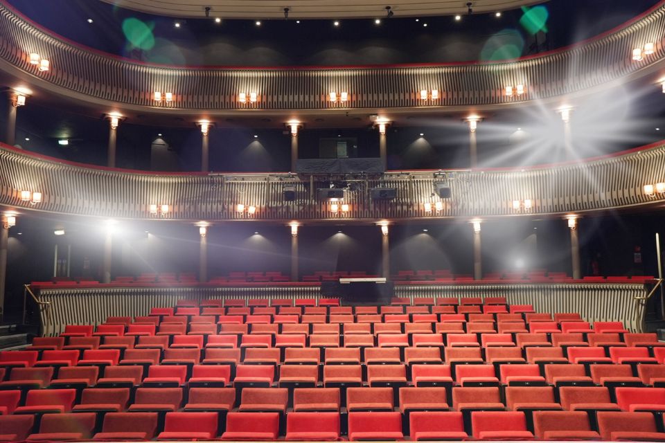 A theatre auditorium with red sheets and shining lights