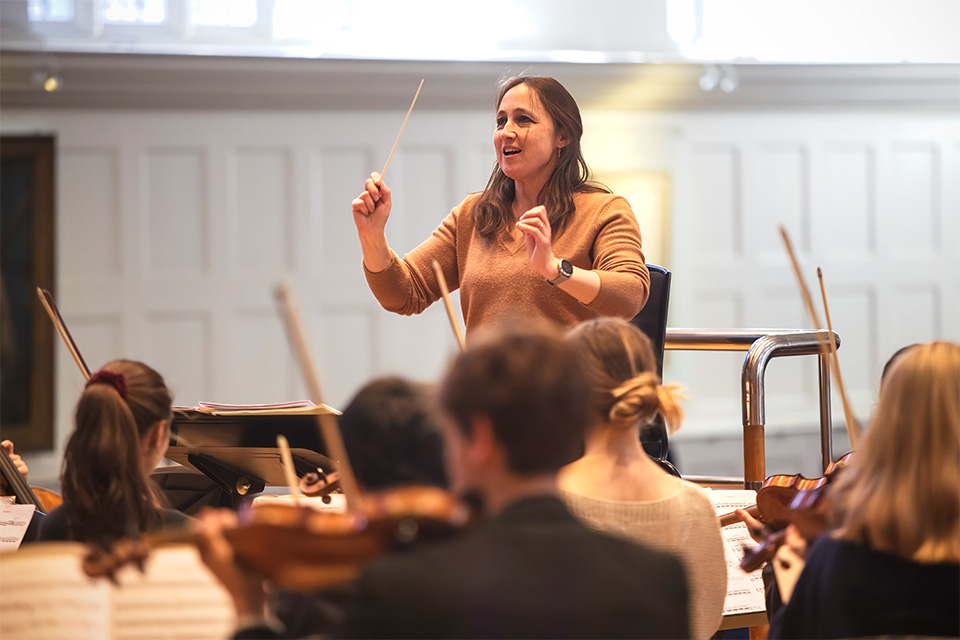 Joana Carneiro conducts an orchestra on stage