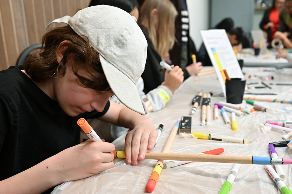 A young girl draws with colourful pens