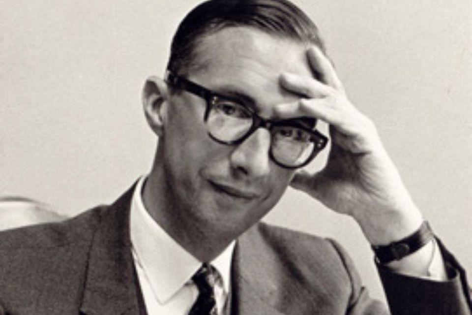 A black and white photo of Anthony Milner wearing a suit and looking to camera