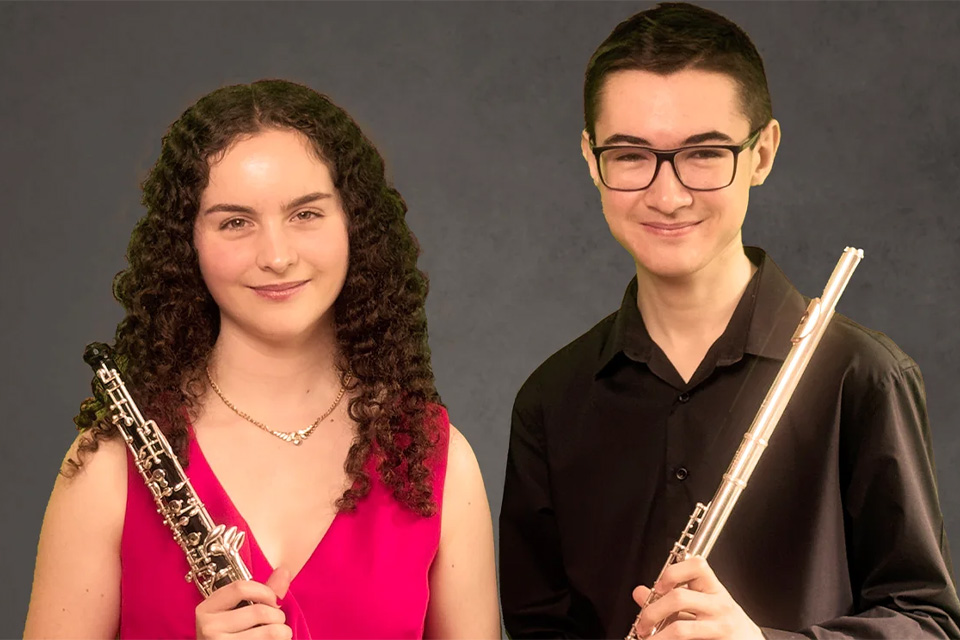 Emilia Gahan and Isaac Skey stand next to each other holding their instruments