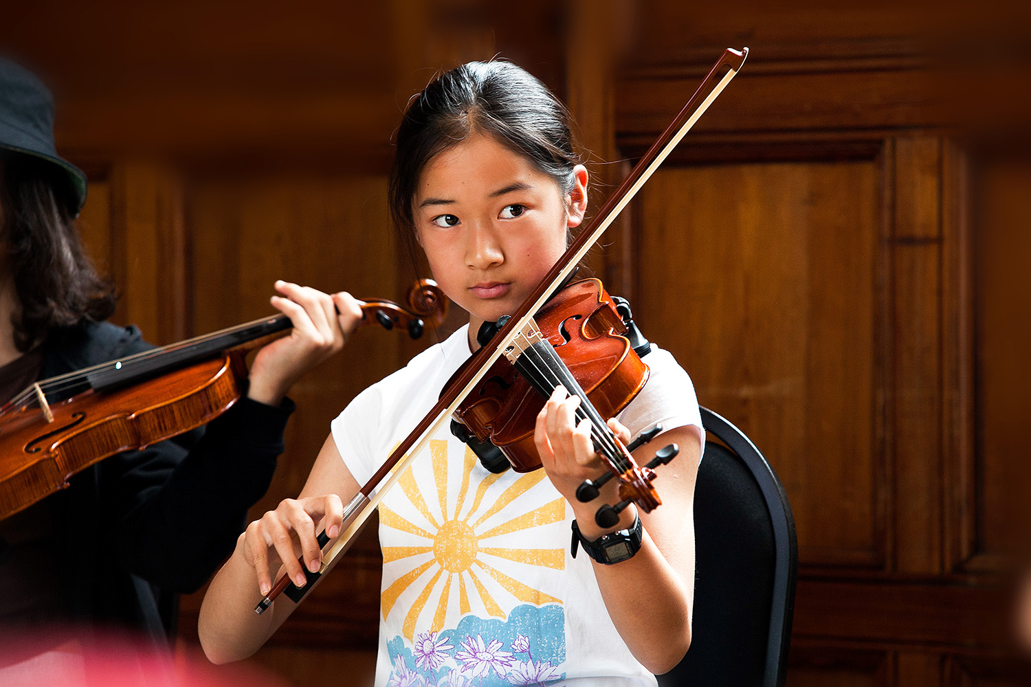 A young girl plays the violin