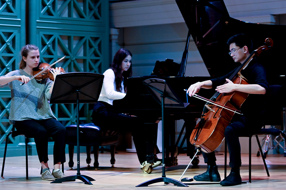 A piano trio perform on stage