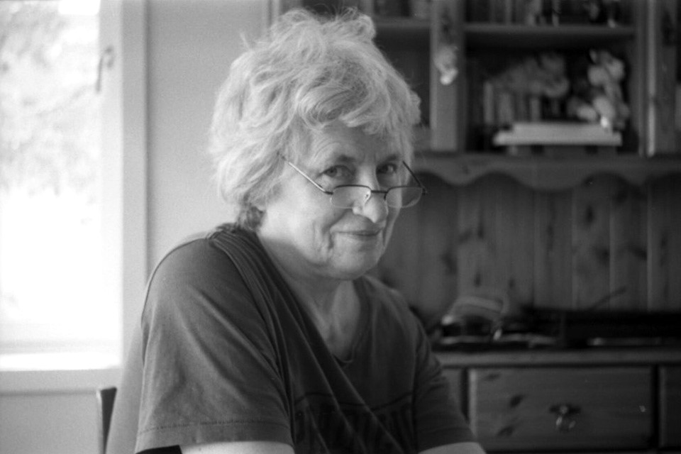 A black and white photo of Frøydis Ree Wekre looking over her shoulder and smiling softly