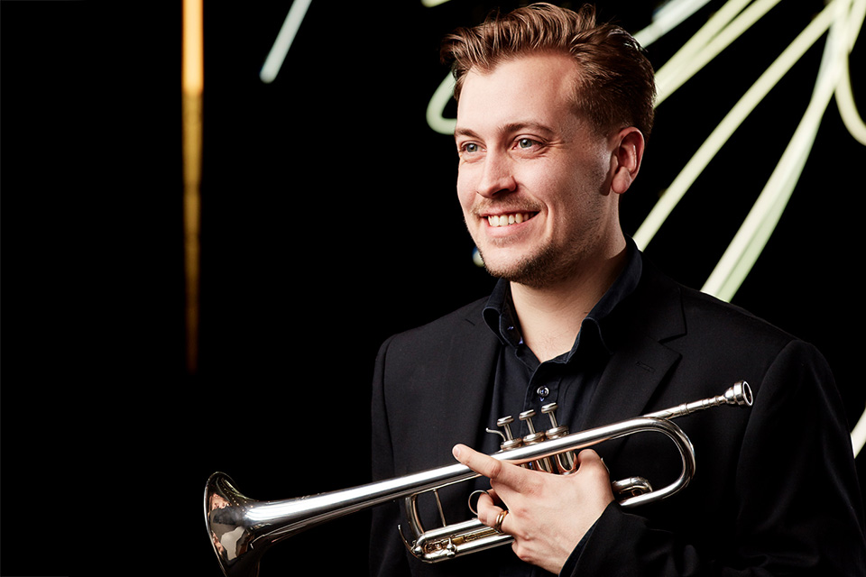 Trumpeter Gustav Melander, pictured wearing black in front of a dark background
