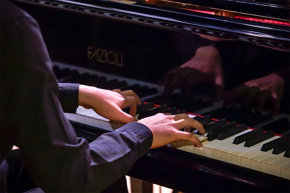 A close up shot of two hands playing a piano