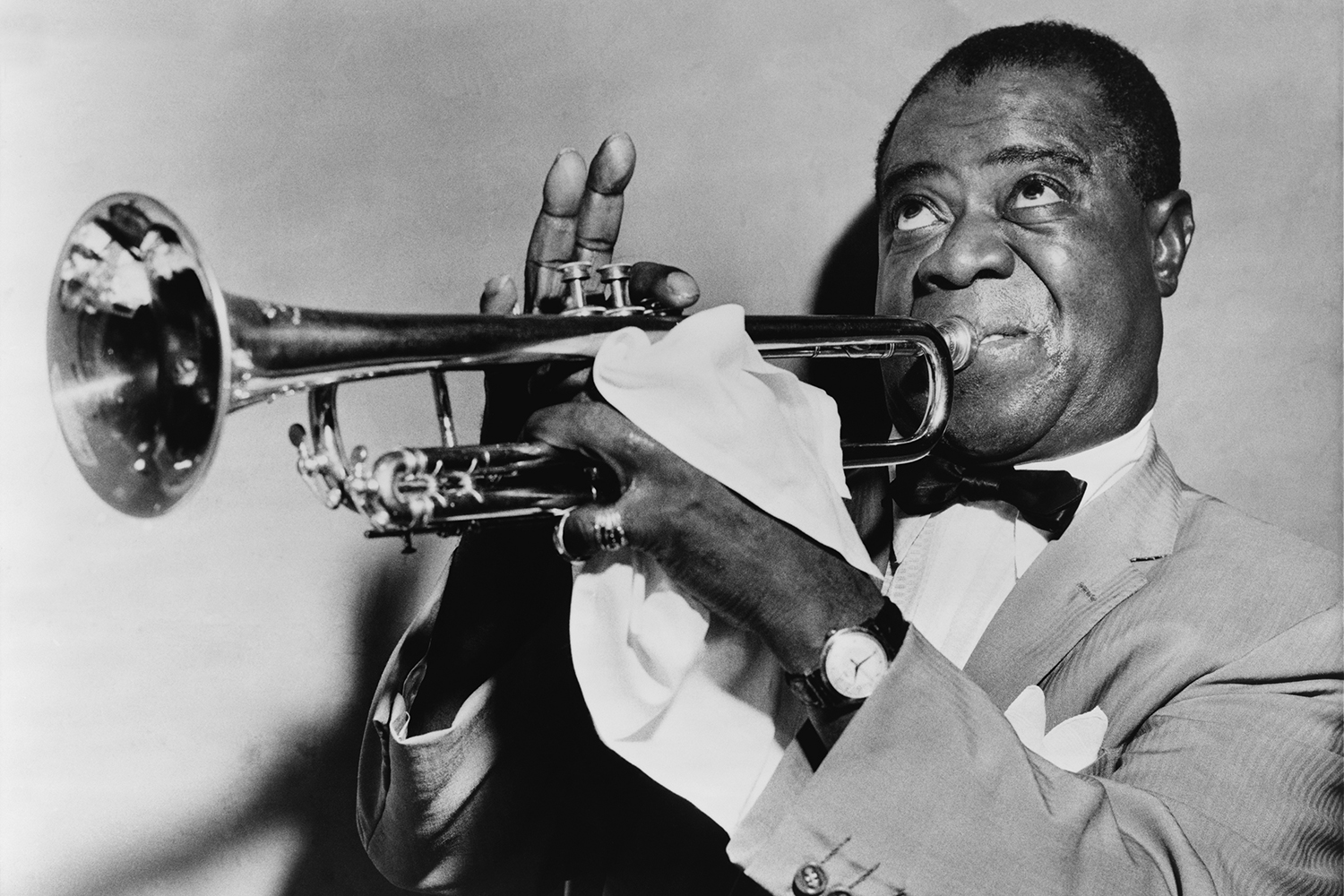 A black and white photo of Louis Armstrong performing on a trumpet