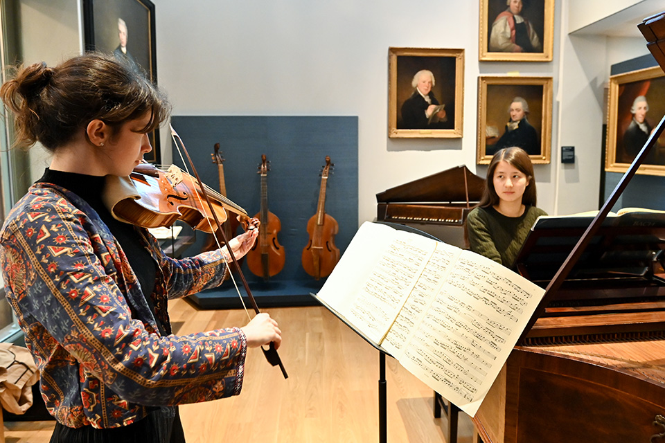 A violinist and pianist performing in the RCM museum