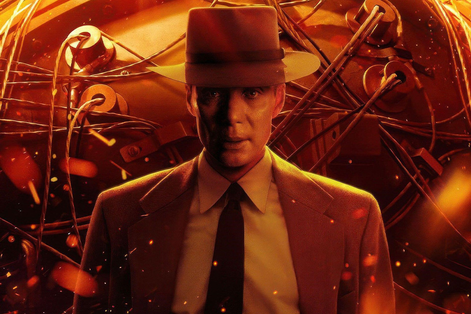 An orange movie poster of actor Cillian Murphy as Oppenheimer wearing a suit and tie and bowler hat