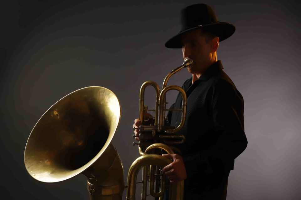 Jens Bjørn-Larsen wears black glasses and holds his tuba in front of him
