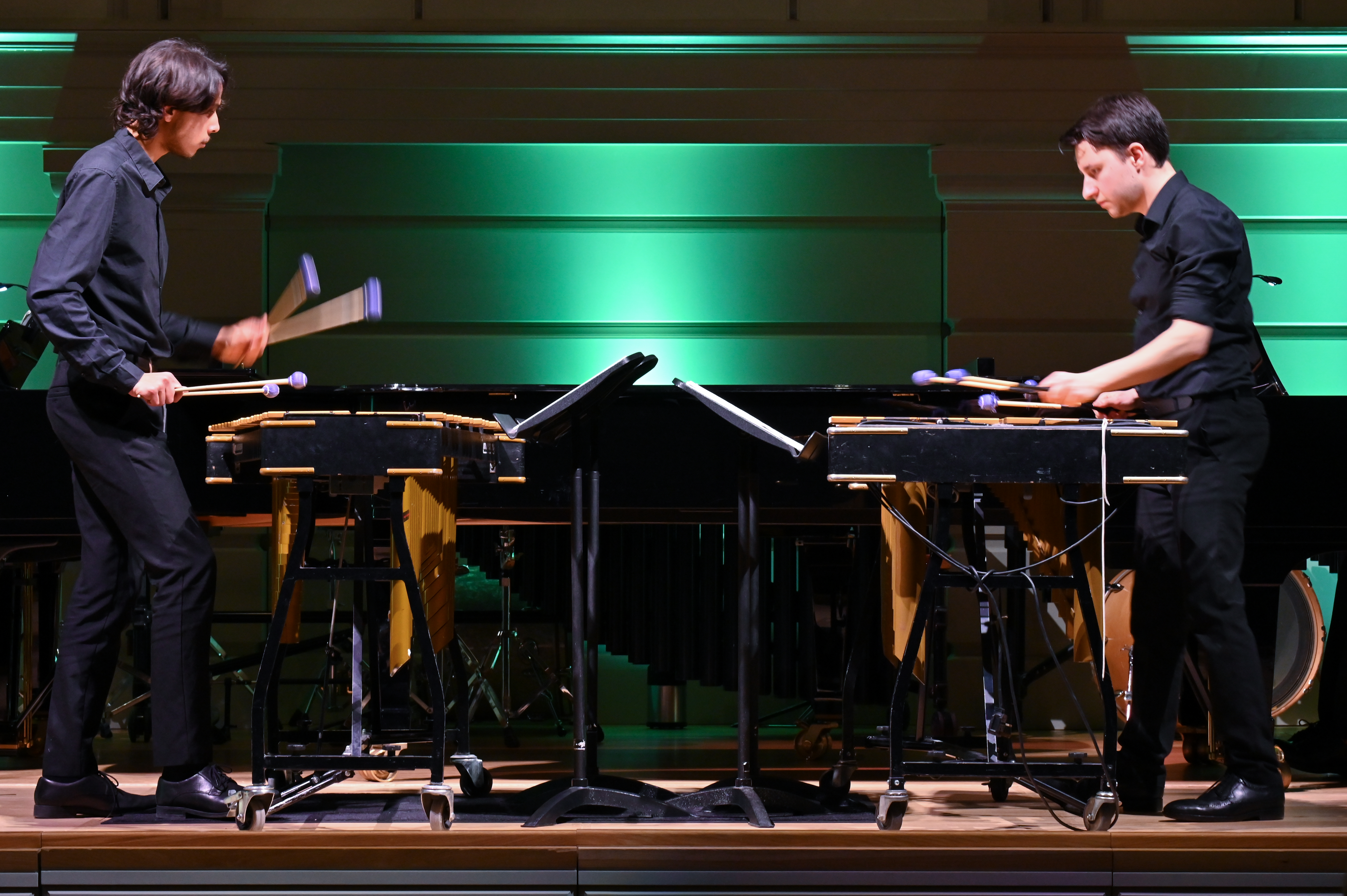 Two percussionists perform on drums on stage