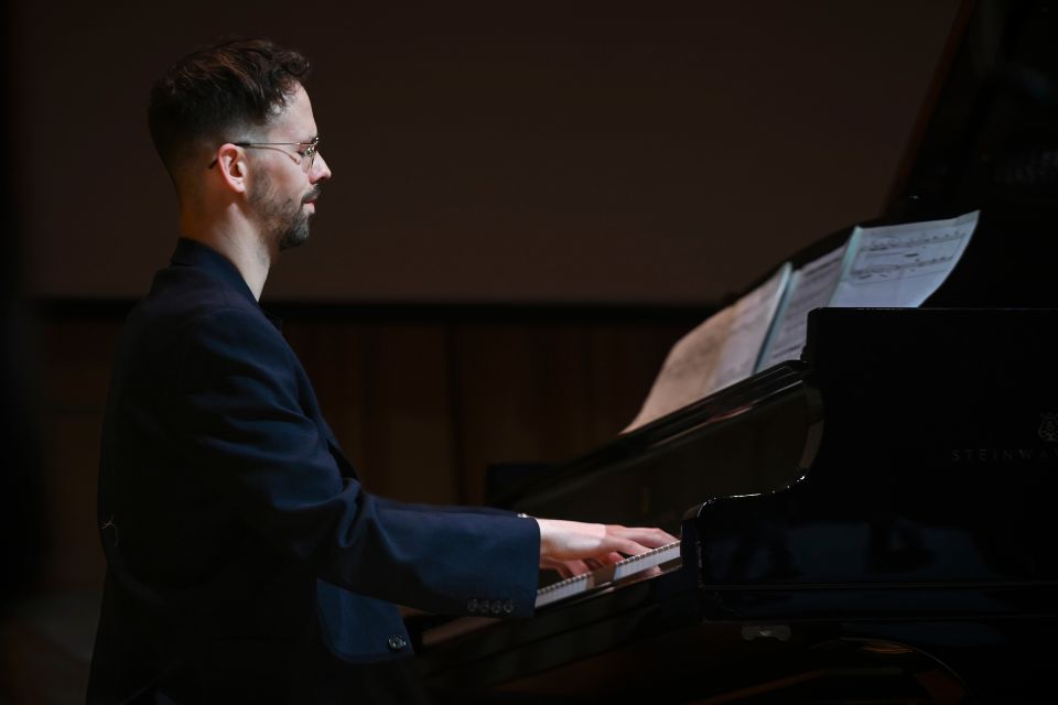 A young man plays the piano on stage
