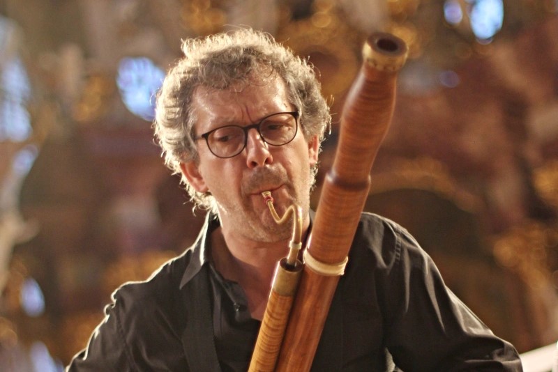 A man in a black shirt performing on a bassoon