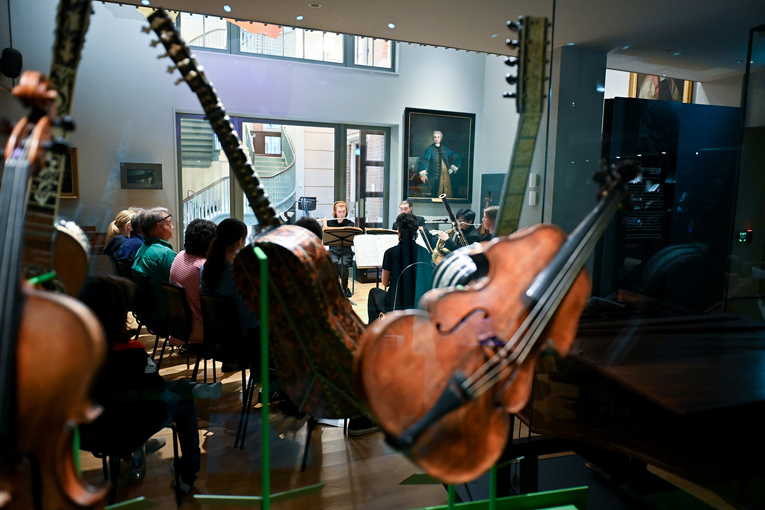 Close up instruments in the RCM Museum with musicians performing in the background