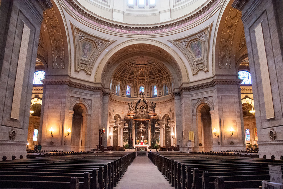 Inside the dome of St Paul's Cathedral: impressive architecture with elalborately carved pillars and walls surrounding the church pews and altar