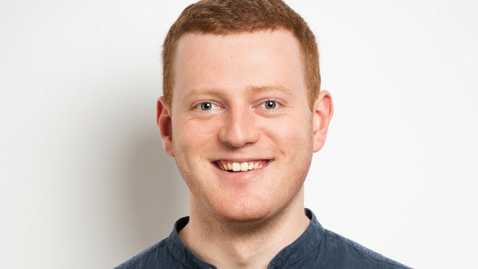 Portrait photo of male alumnus looking directly at the camera and smiling