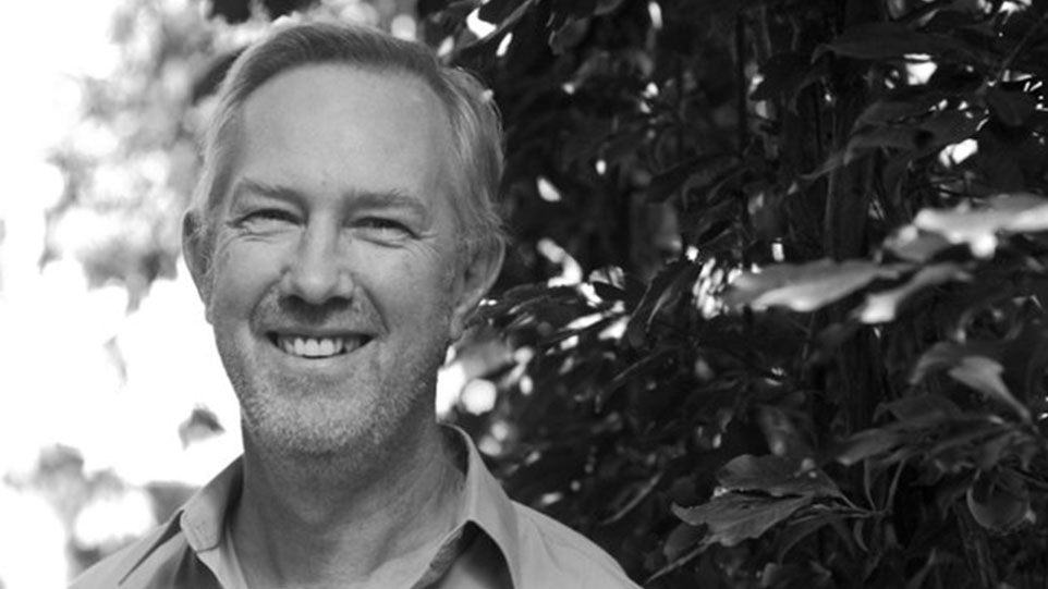 Roy Howat: A smiling man stands in front of lush green trees, conveying a sense of joy and connection with nature.