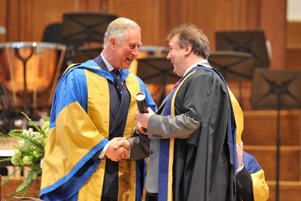 A photo of the President, His Royal Highness the former Prince of Wales, congratulating someone who has become granted a fellowship.